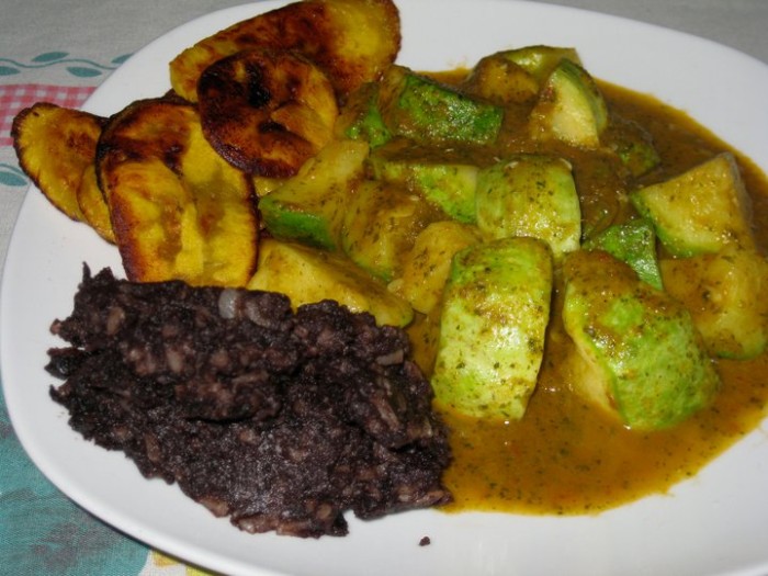 Pepian, an indigenous sauce of pumpkin seeds, tomatoes, and spices, is served here with squash, fried plantains, and refried black beans.