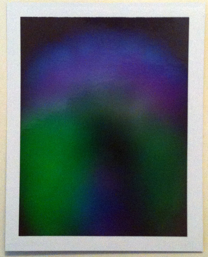Aura photograph of purple and green shades on a black background. 