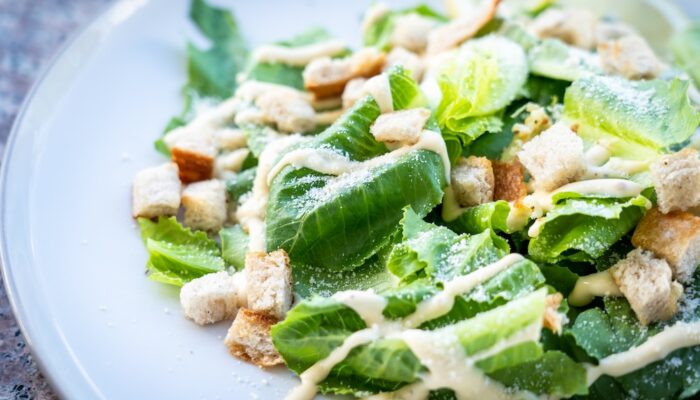 vegan caesar salad with chickpeas drizzled with creamy dressing