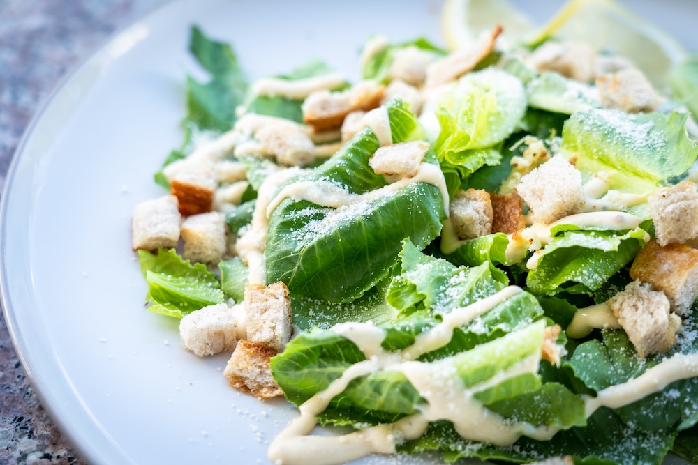 vegan caesar salad with chickpeas drizzled with creamy dressing