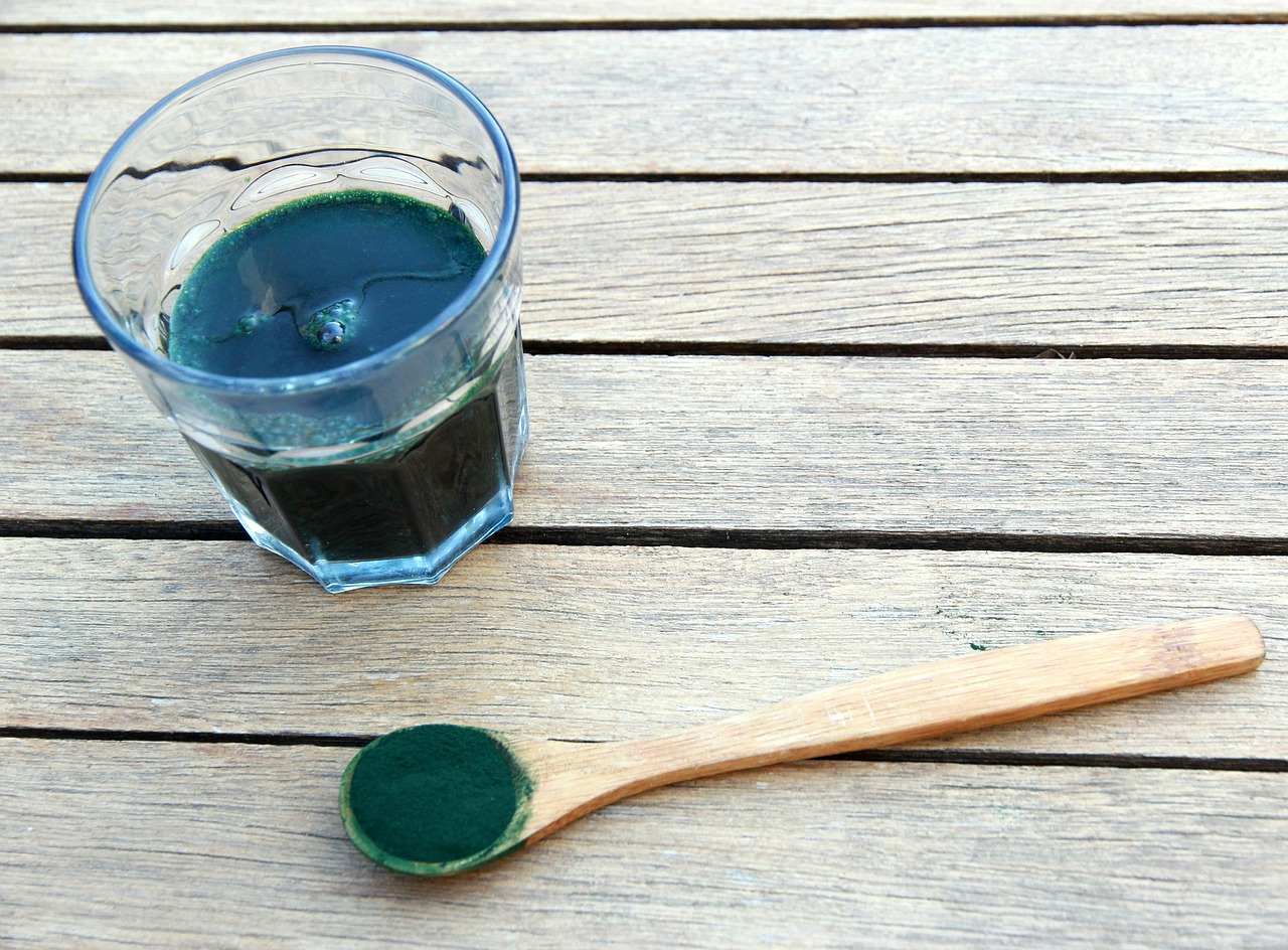 spoon of spirulina next to drink