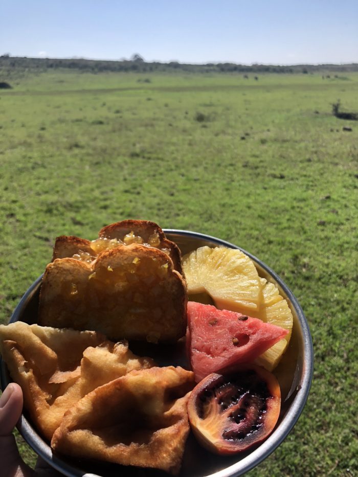 Vegan breakfast of mandazi, fruits and toast on the African plains