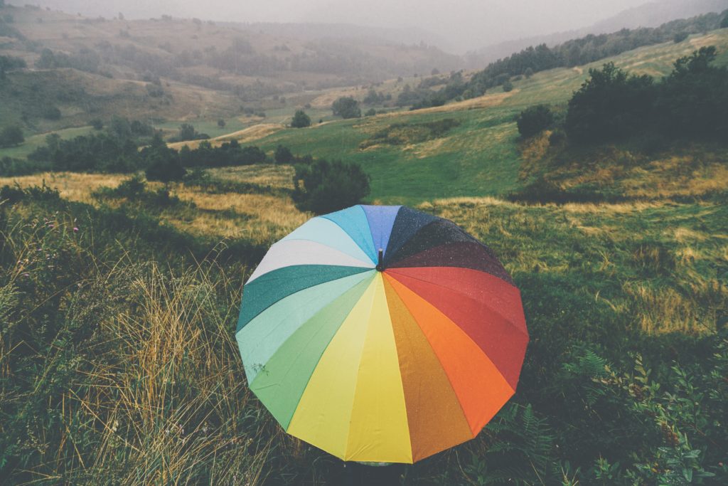 Rainbow umbrella amidst nature at the hills