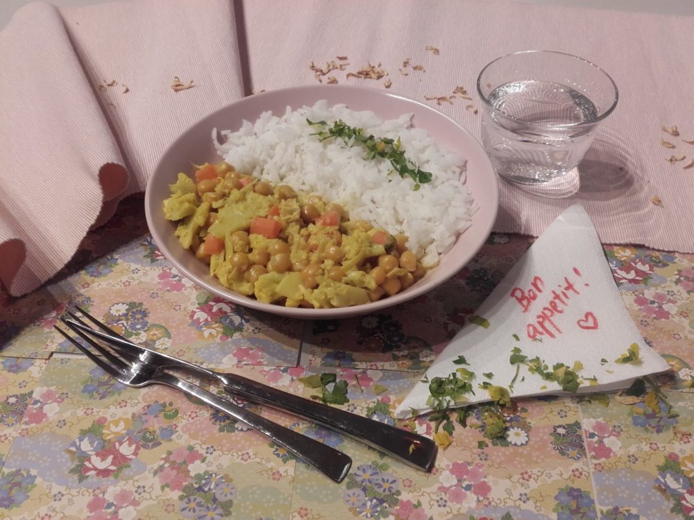 vegan cauliflower curry with chickpeas on a table with silverware