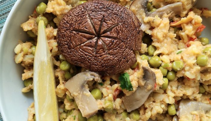 Vegan paella with mushrooms and peas in a white dish