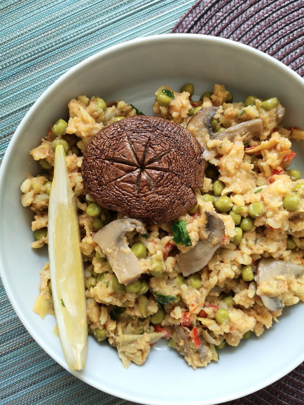 Vegan paella with mushrooms and peas in a white dish