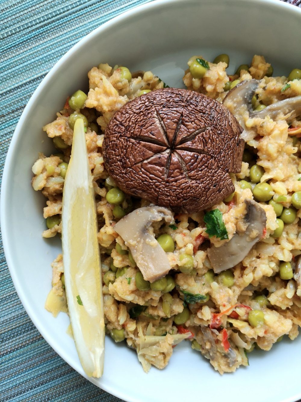 Vegan paella with mushrooms and peas in a white dish