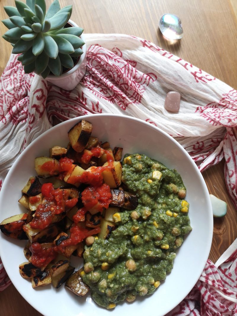 vegan patatas bravas with chickpeas in spinach sauce on a white plate