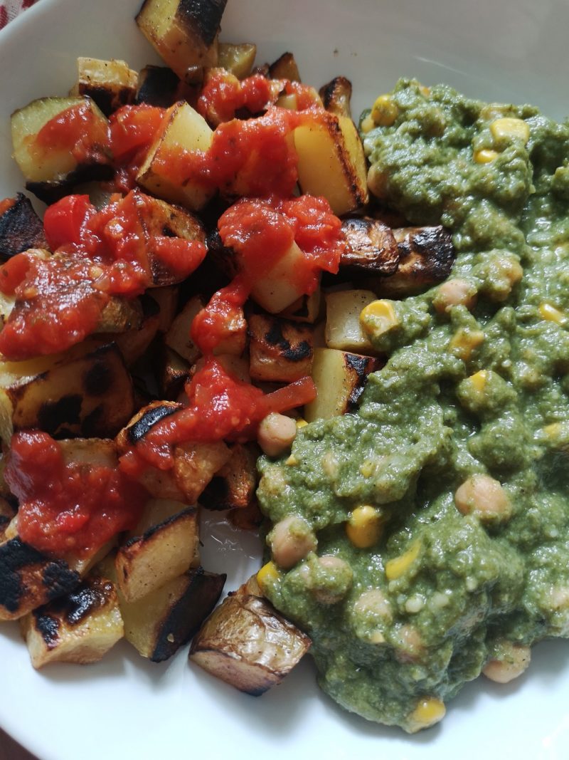 vegan patatas bravas with chickpeas in spinach sauce on a white plate