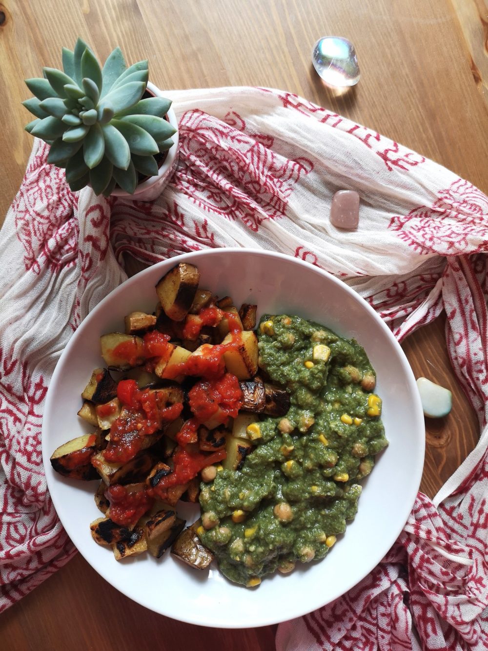 vegan patatas bravas with chickpeas in spinach sauce on a white plate