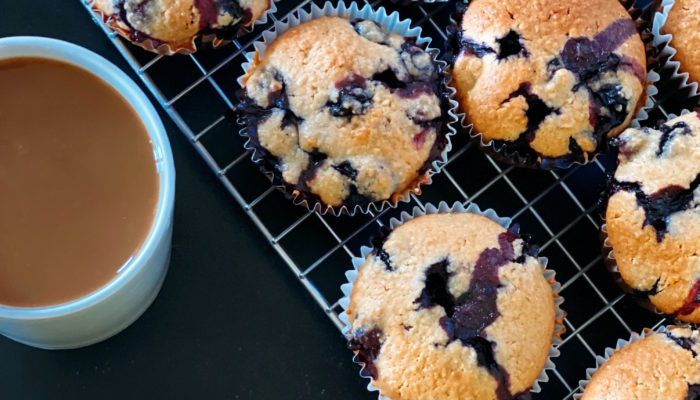 bakery style vegan blueberry muffins on a cooling rack