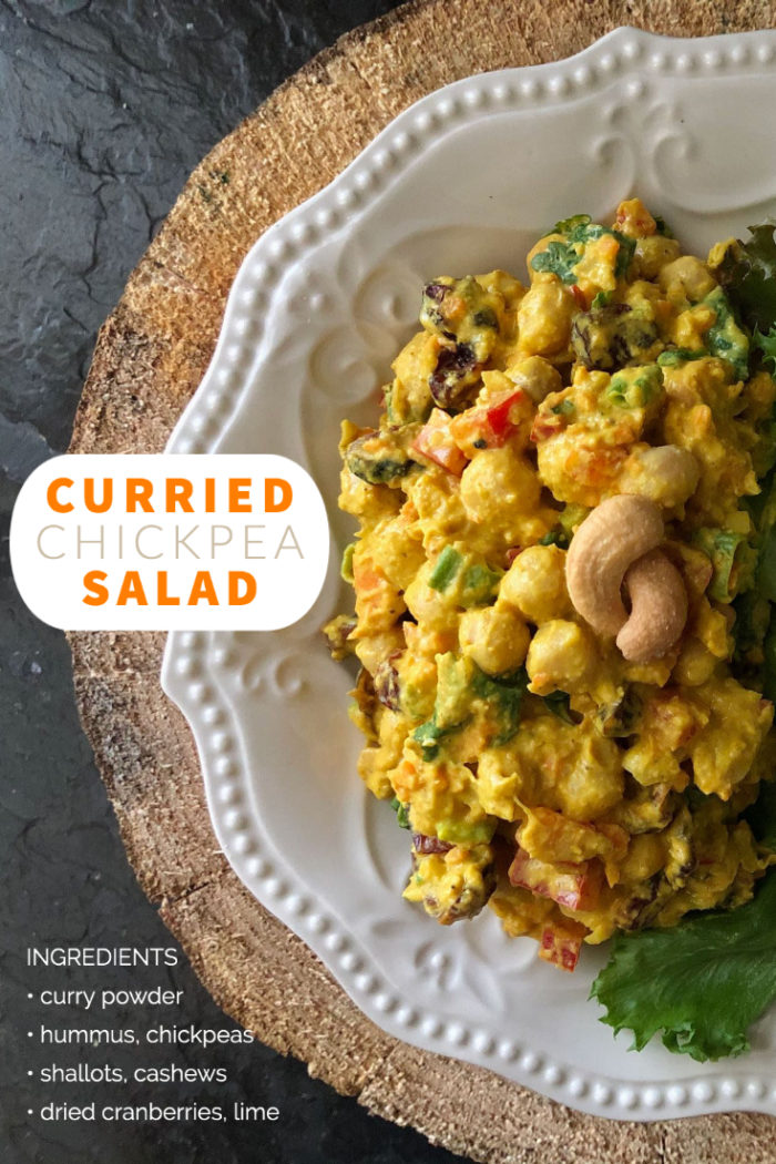 curried chickpea salad on a white plate with a brown and black background and overlayed caption with ingredients
