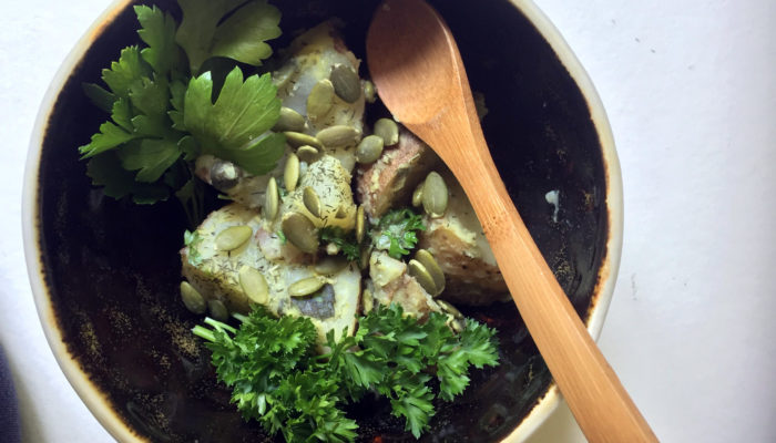 vegan potato salad in a bowl with a wooden spoon