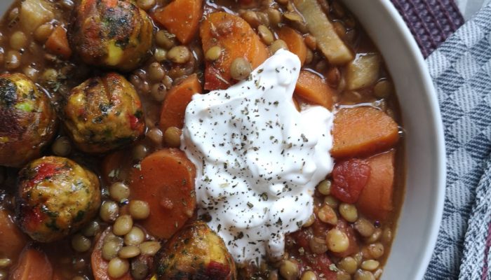 vegan lentil ragout with tomato and veggie balls in a white bowl