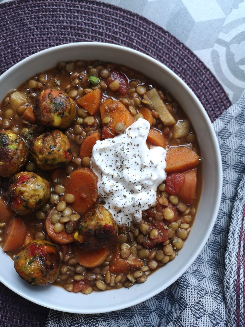 vegan lentil ragout with tomato and veggie balls in a white bowl