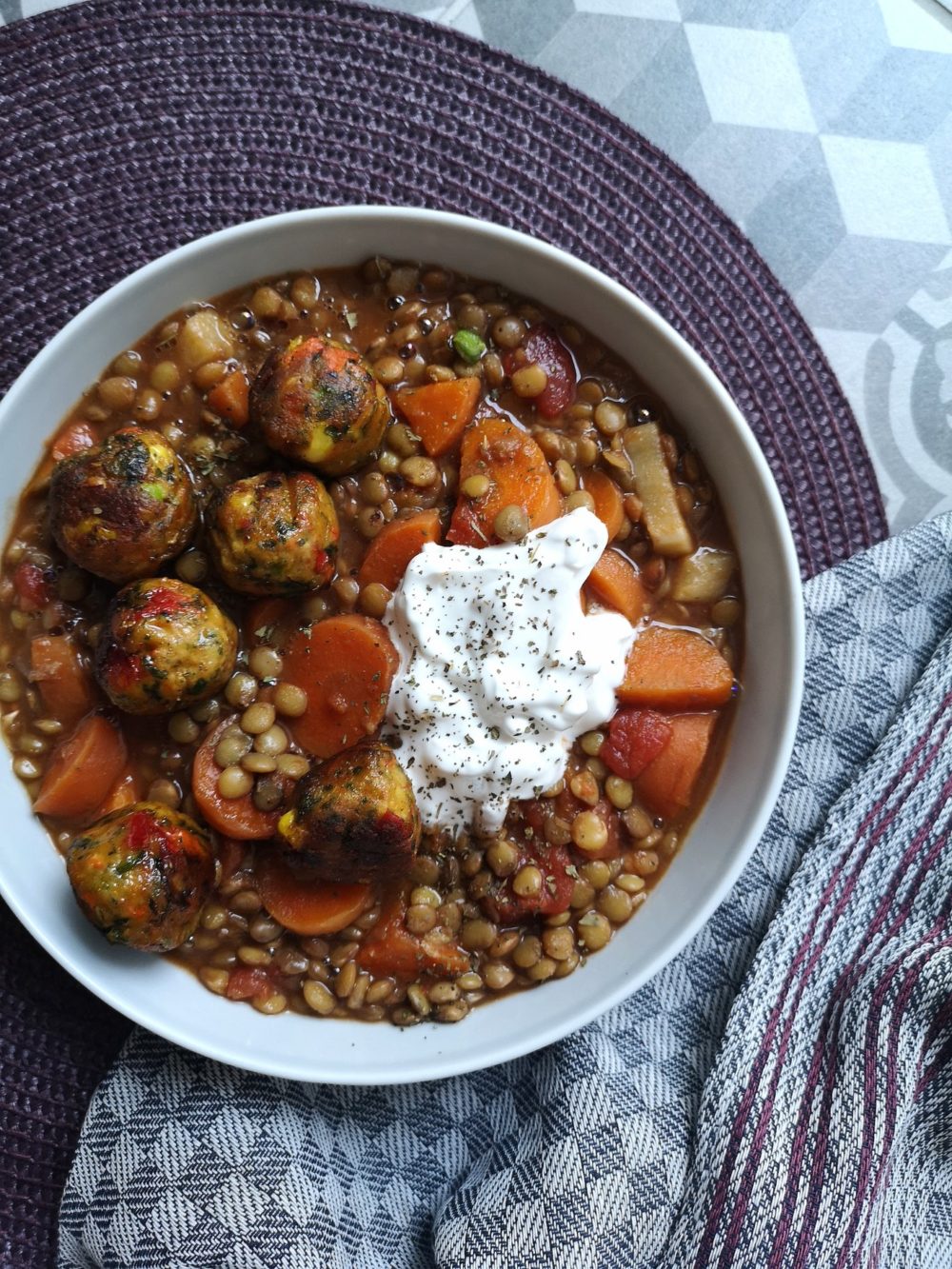 vegan lentil ragout with tomato and veggie balls in a white bowl