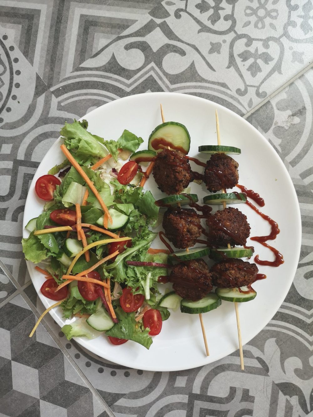 bbq vegan meatless balls and salad on a white plate