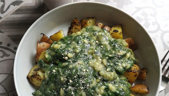 Vegan Creamed Spinach in a white bowl next to a succulent