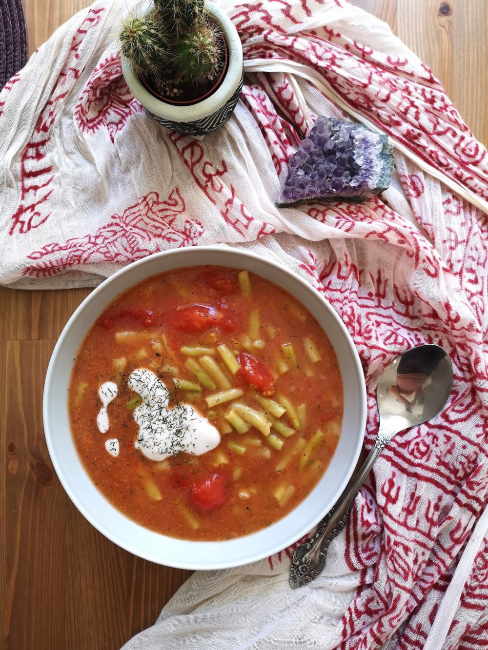 String Bean Soup in a bowl next to a cactus and a purple crystal