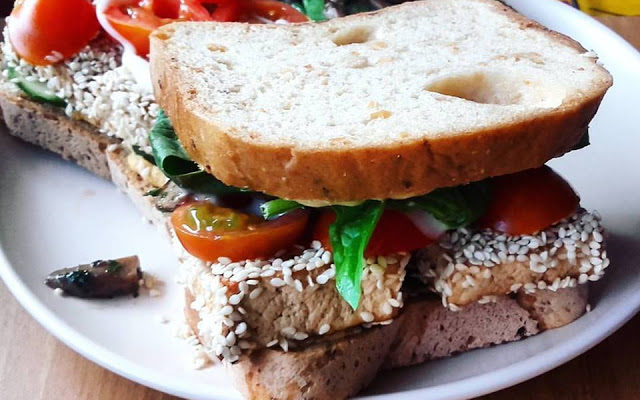 vegan grilled sesame tofu sandwich on a white plate