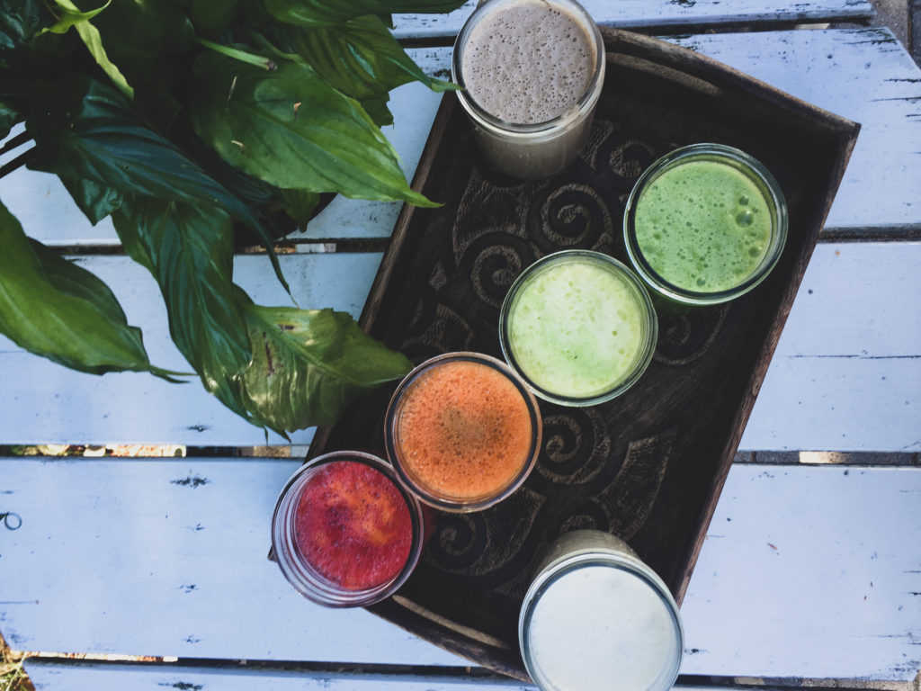 rainbow juices on a wooden tray