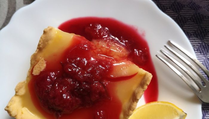 lemon pudding pie on a white plate with a fork