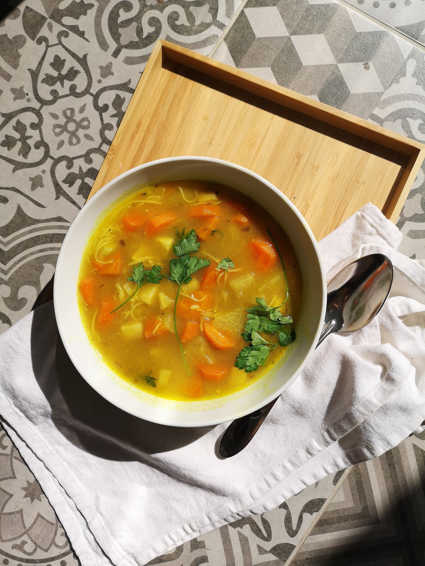 heirloom vegan hungarian thread noodle soup in a white bowl with a spoon