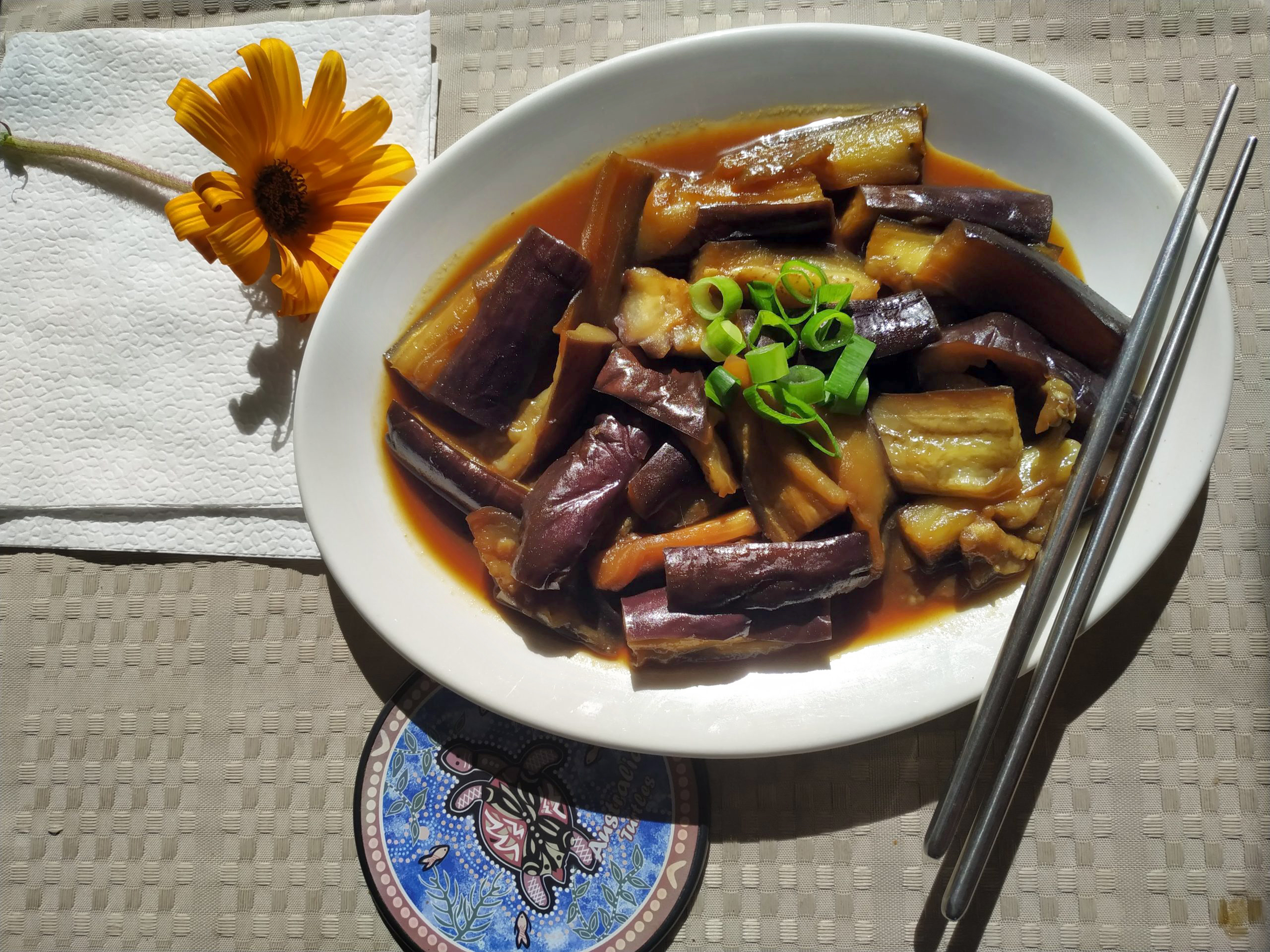 stir fried eggplant with sweet and spicy garlic sauce in a white dish