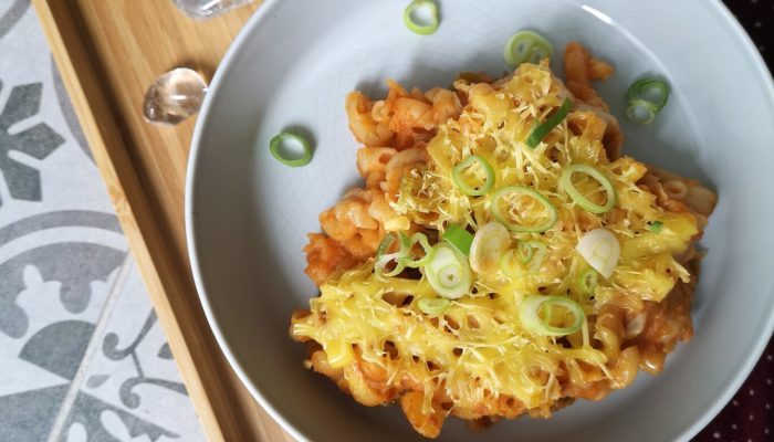 vegna kimchi mac n cheese on a white plate with a spoon