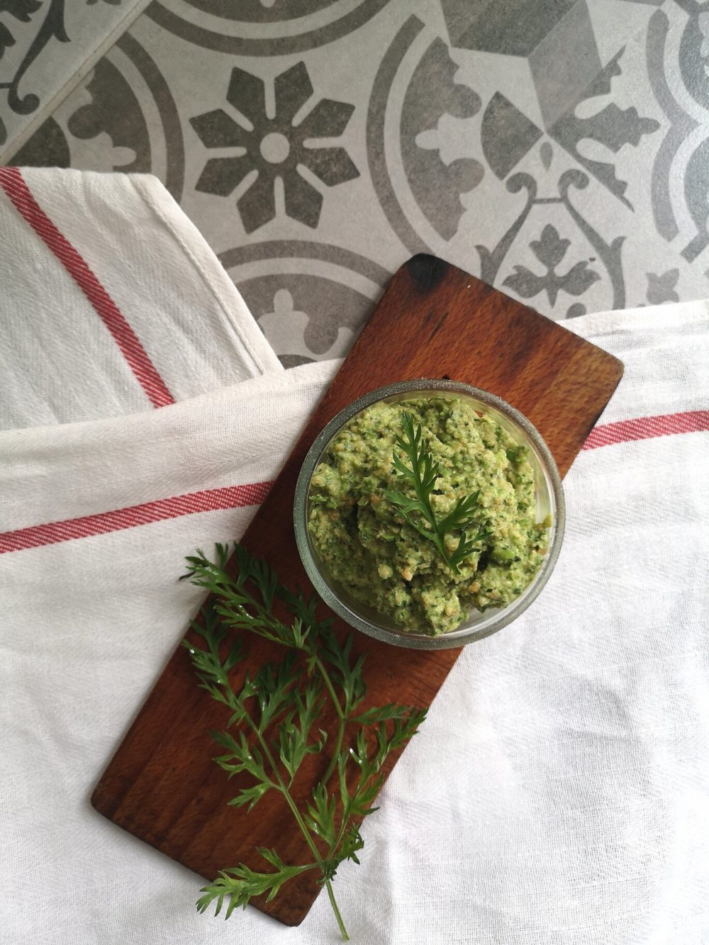 carrot top pesto in a clear dish on a cutting board
