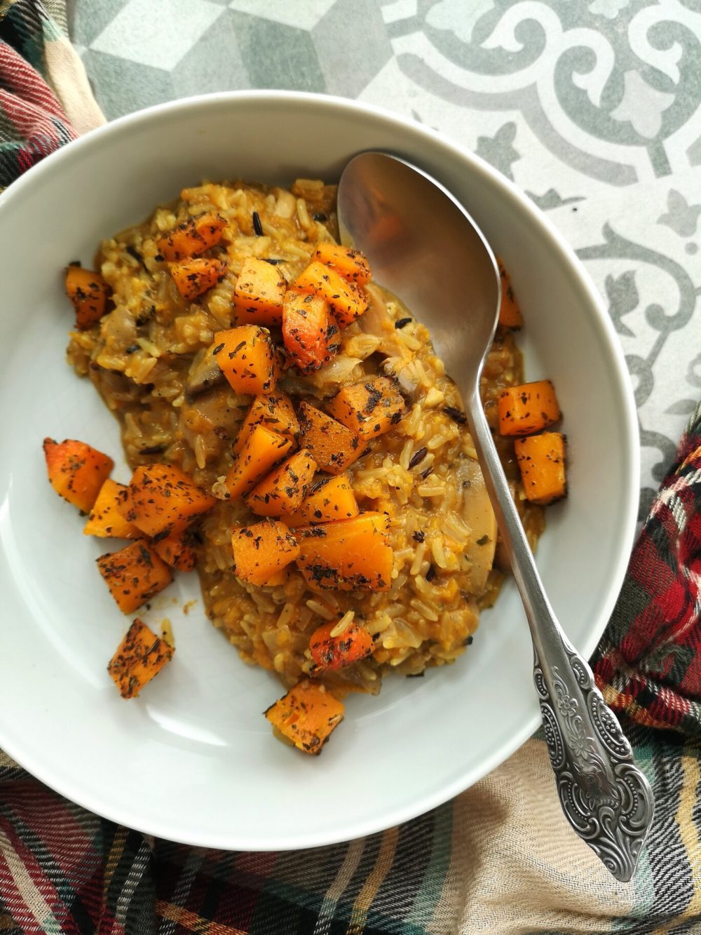 pumpkin wild rice risotto on a white plate with a spoon