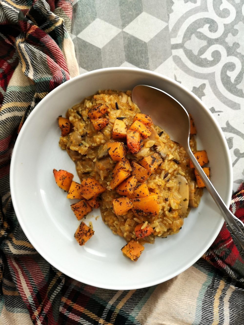 pumpkin wild rice risotto on a white plate with a spoon
