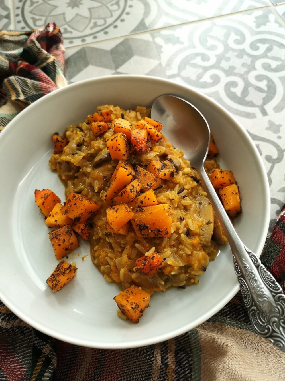 pumpkin wild rice risotto on a white plate with a spoon