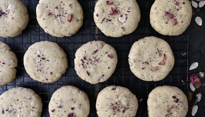 vegan cardamom rosewater shortbread cookies against a dark background