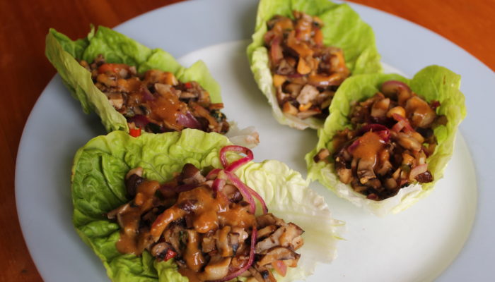 vegan mushroom larb lettuce boats on a white plate