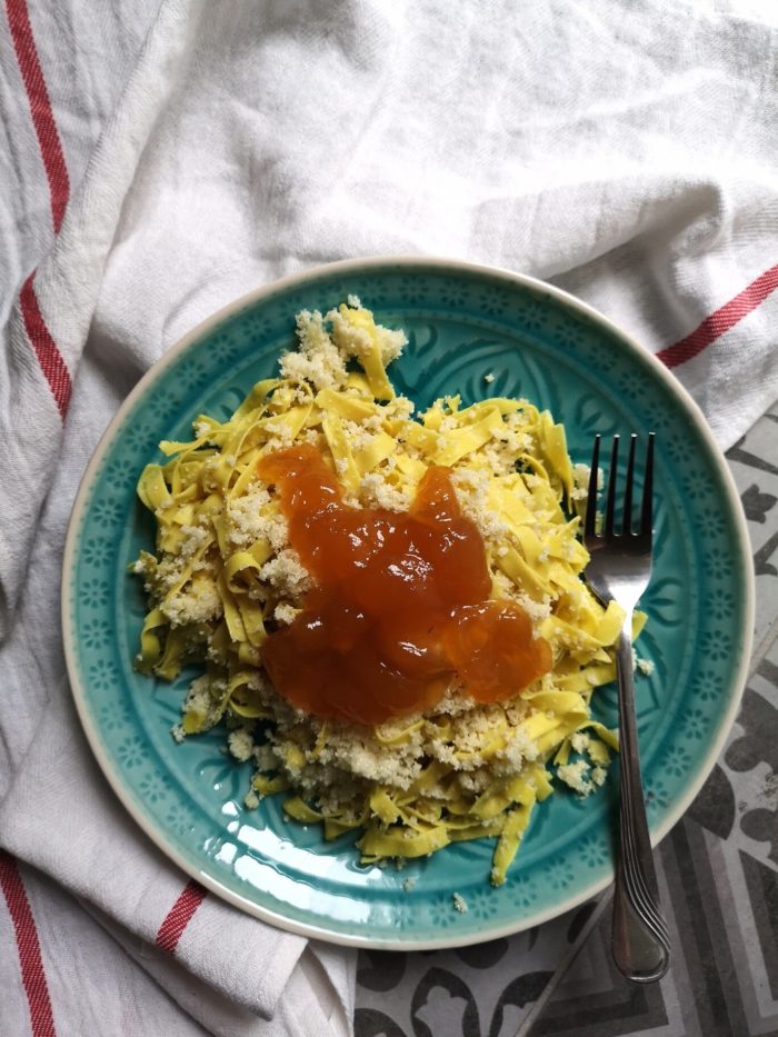 vegan hungarian noodles on a teal plate with a fork