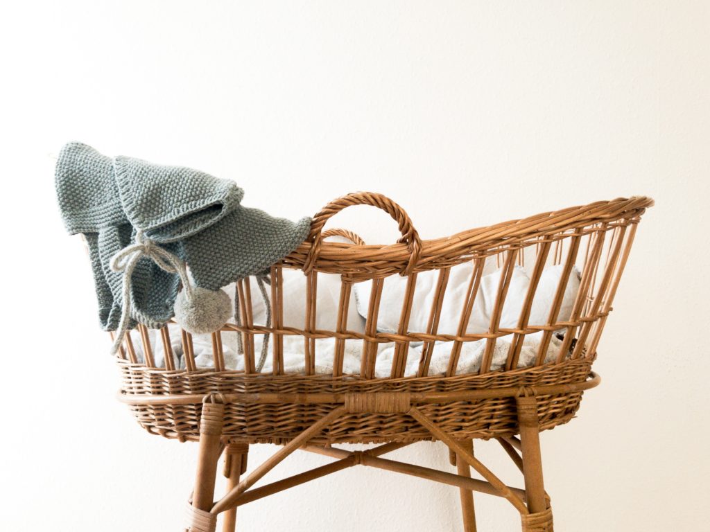 Wicker baby's crib with a blanket