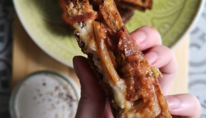a hand holding kimchi grilled cheese