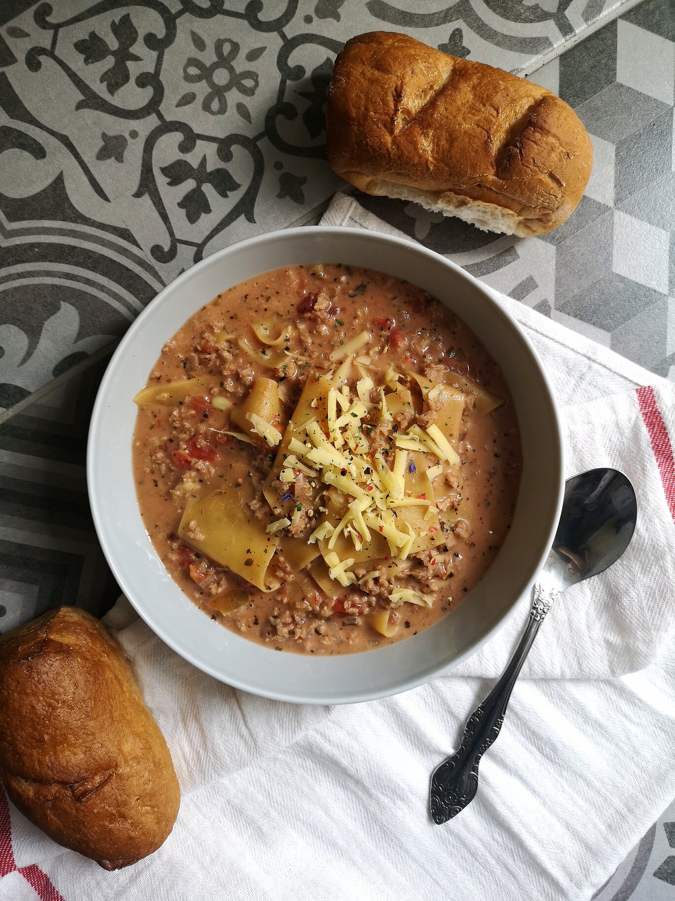 vegan lasagna soup with bread and a spoon