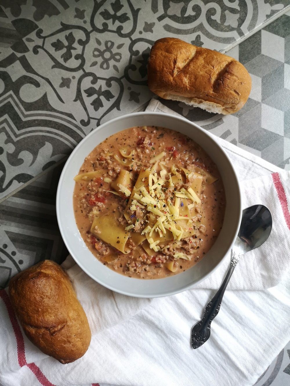 vegan lasagna soup with bread and a spoon