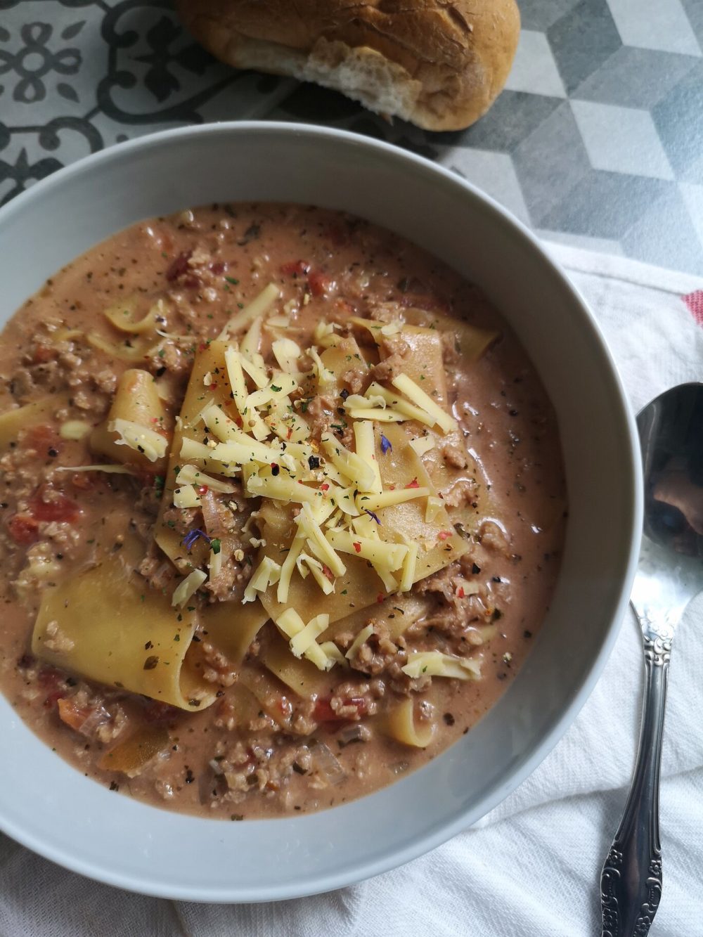 vegan lasagna soup with bread and a spoon