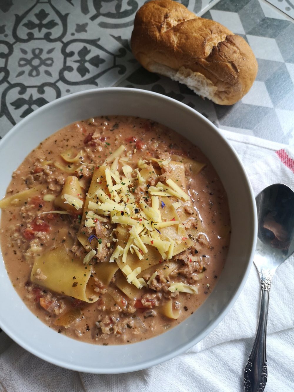 vegan lasagna soup with bread and a spoon