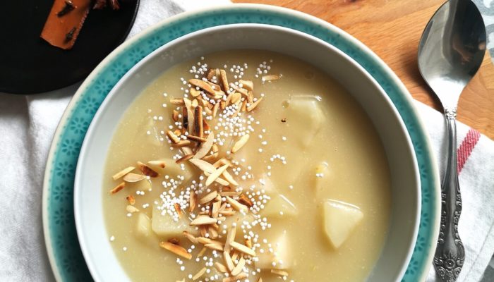 pear porridge in a bowl next to a spoon