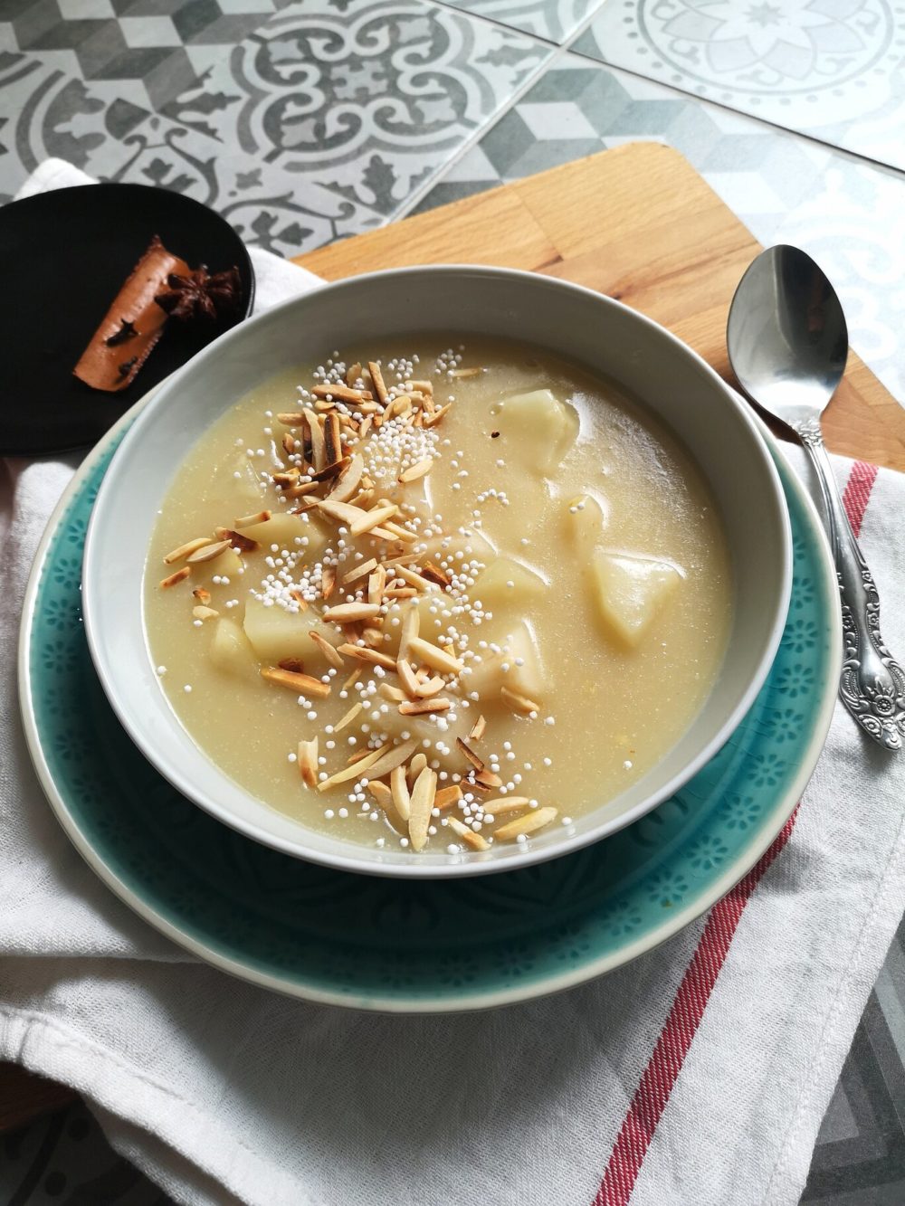 pear porridge in a bowl next to a spoon