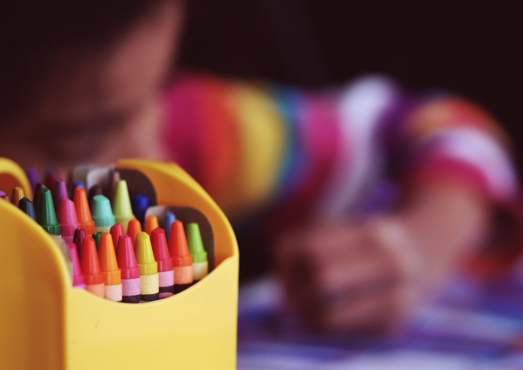 A young student studying using crayons