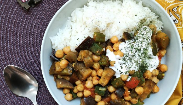 curried okra in a dish next to a spoon