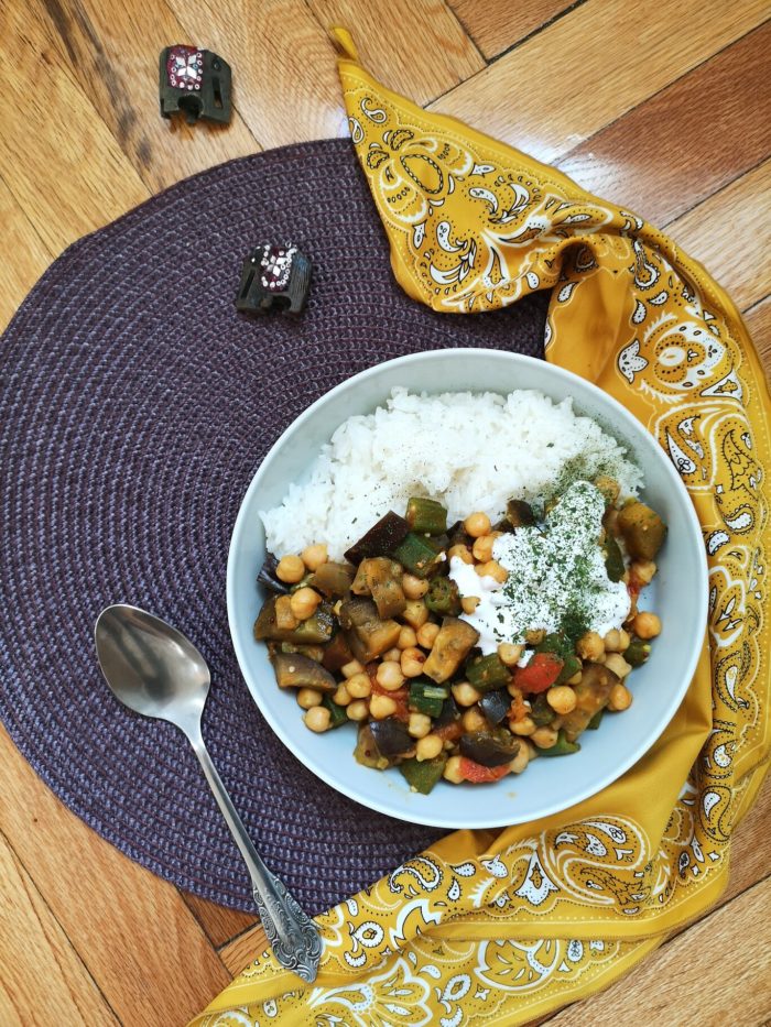 curried okra in a dish next to a spoon