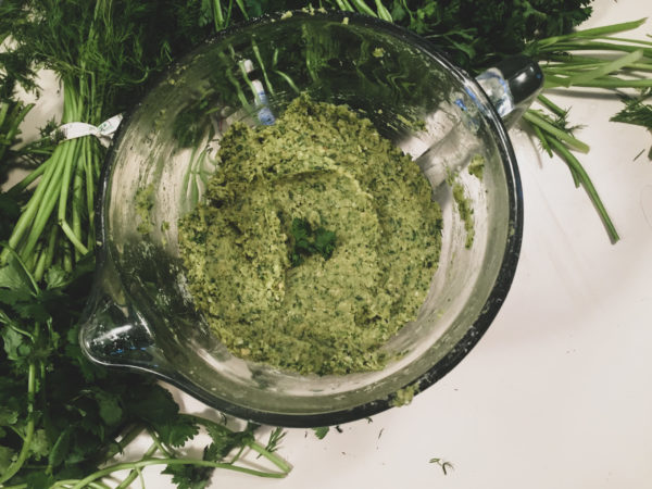 falafel mixture in a glass dish next to greens