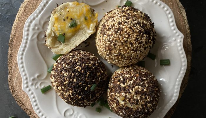 stuffed bagel bites on a white plate against a brown and black background