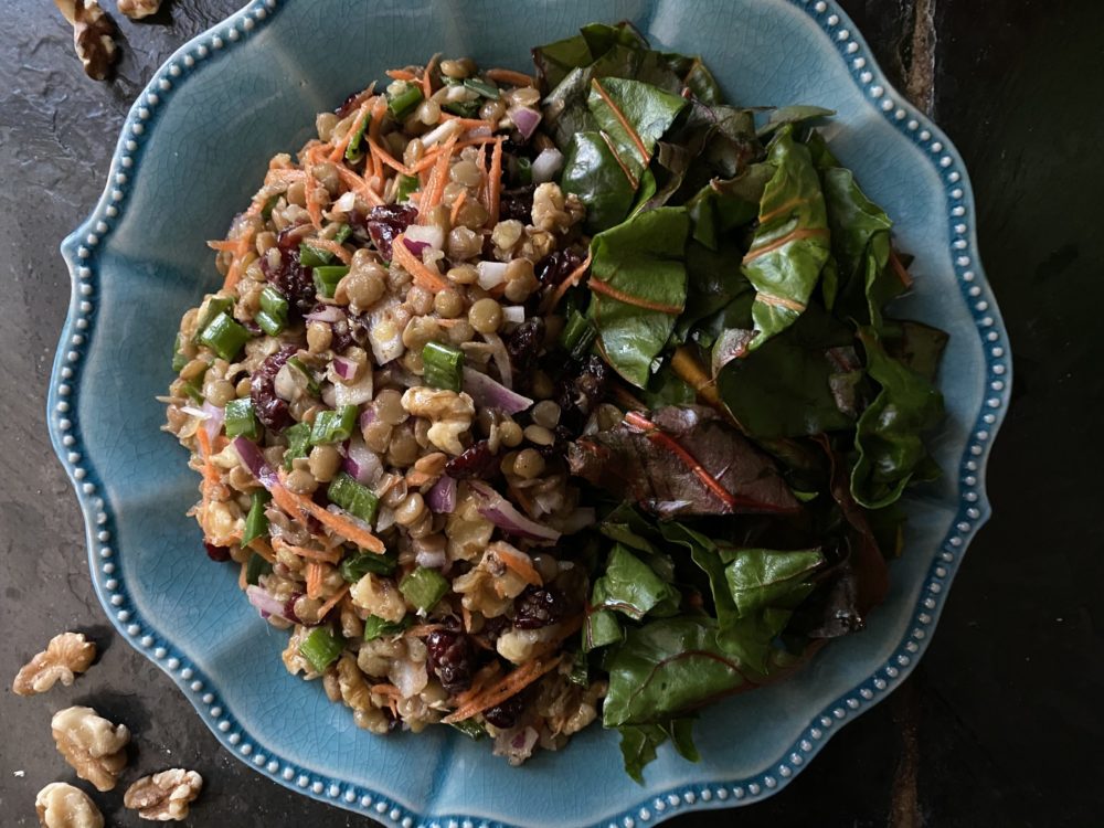 maple dijon lentil salad on a blue bowl against a black background